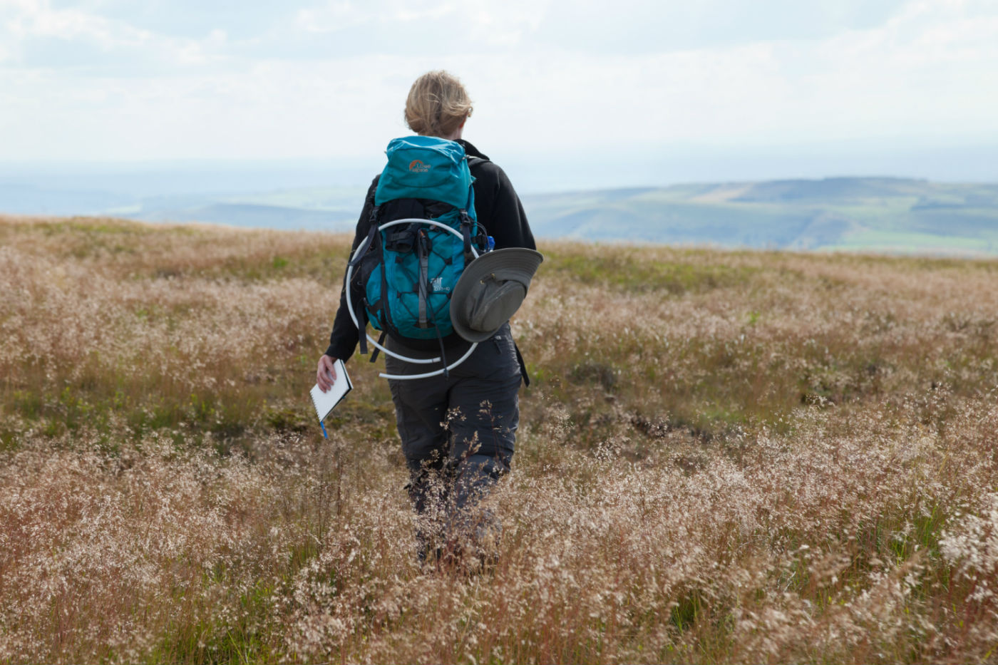 Walker navigating through grasslands of Combs Moss