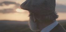 Picture of a farmer looking out to the sun setting 