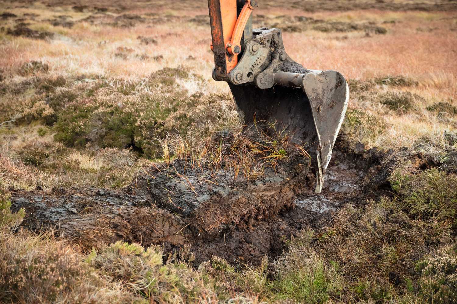 A peat dam being created with a digger